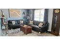 Cozy living room featuring dark leather couches, rug, and a grandfather clock at 3506 Moog Rd, Holiday, FL 34691
