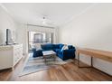 Bright living room features a blue sectional sofa, wood floors, and sliding glass doors to a balcony at 501 Knights Run Ave # 2101, Tampa, FL 33602