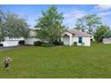 Inviting home with a manicured lawn and mature trees, with a side entry garage, and a covered entryway at 5331 Berrien Ave, Spring Hill, FL 34608