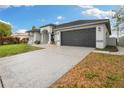 Contemporary one-story home featuring a spacious driveway and well-kept landscaping at 6140 Silver Oaks Dr, Zephyrhills, FL 33542