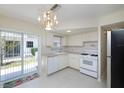 Well-lit kitchen featuring white cabinetry and a sliding door to the outside at 7847 39Th N Ter, St Petersburg, FL 33709