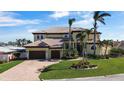 Charming two-story home featuring a well-manicured lawn, brick driveway, and a two-car garage at 7986 9Th S Ave, St Petersburg, FL 33707