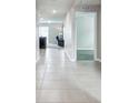 Bright hallway with tile flooring, neutral walls, and open doorways into other living spaces at 8034 Broad Pointe Dr, Zephyrhills, FL 33540
