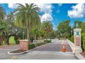 Inviting entrance to Belleair Country Club with palm trees and beautifully manicured landscape at 100 Oakmont Ln # 112, Belleair, FL 33756
