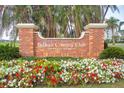 An inviting Belleair Country Club sign is surrounded by flowers and lush palm trees at 100 Oakmont Ln # 112, Belleair, FL 33756