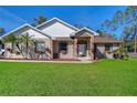 Inviting single-Gathering home featuring a well-maintained lawn and a welcoming front entrance at 12102 Hazen Ave, Thonotosassa, FL 33592