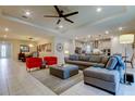 Spacious open-concept living room with modern decor, tile flooring, and seamless flow to the kitchen at 12704 Palapa Loop, Spring Hill, FL 34610