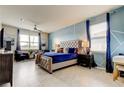 Serene main bedroom with tufted headboard, stylish blue accent wall, and lots of natural light at 12704 Palapa Loop, Spring Hill, FL 34610