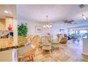 Bright dining area features travertine floors, barstool seating, and a seamless transition to the living room at 19029 Us Highway 19 N # 29E, Clearwater, FL 33764