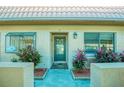 Inviting front entrance featuring a tiled walkway, lush landscaping, and a secure, modern front door at 19029 Us Highway 19 N # 29E, Clearwater, FL 33764