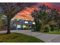 Charming blue two-story home with lush landscaping and mature trees in a desirable neighborhood at 1975 Levine Ln, Clearwater, FL 33760