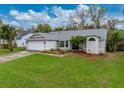 Attractive single-story home featuring a lush lawn, gray roof and manicured landscaping at 2745 Horseshoe Dr, Plant City, FL 33566