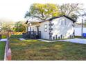 Beautifully landscaped exterior with gray trim, new paved driveway, and green lawn at 3012 E 149Th Ave, Lutz, FL 33559