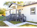 Charming front entrance with a welcoming porch, gray trim, and well-maintained landscaping at 3012 E 149Th Ave, Lutz, FL 33559