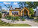 Delightful yellow home with a brick walkway, verdant landscaping, and covered front porch at 3235 8Th N Ave, St Petersburg, FL 33713