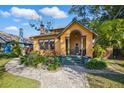Charming yellow home with a brick walkway, lush landscaping, and inviting front porch at 3235 8Th N Ave, St Petersburg, FL 33713