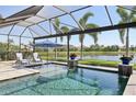 Beautiful screened-in pool with lounge chairs and views of the water and palm trees at 4857 Tobermory Way, Bradenton, FL 34211