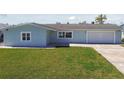 Well-maintained single-story home with lush green lawn, a two-car garage, and a paved driveway and walkway at 5321 Bowline Bnd, New Port Richey, FL 34652