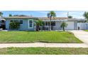 Well-kept single-story home with a green lawn, driveway, and a cozy, covered front porch area at 553 E Lake Dr, Largo, FL 33771