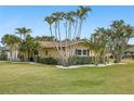 Charming single-story home featuring lush tropical landscaping and a well-maintained lawn at 5815 Bali S Way, St Pete Beach, FL 33706