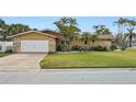 Inviting home exterior with a spacious driveway, lush lawn, and stone accents at 5815 Bali S Way, St Pete Beach, FL 33706