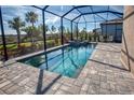 Inviting screened pool and spa surrounded by a brick patio and lush landscaping, creating a private outdoor oasis at 6104 Talon Preserve Dr, Nokomis, FL 34275
