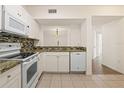 Well-lit kitchen showcases modern appliances, granite countertops, dishwasher, and tile flooring at 6434 Cypressdale Dr # 102, Riverview, FL 33578