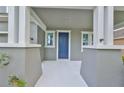 Inviting covered front porch with white columns and blue front door, great curb appeal at 7010 Old Benton Dr, Apollo Beach, FL 33572
