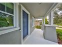 View of the light-filled front porch and blue front door of this inviting home at 7010 Old Benton Dr, Apollo Beach, FL 33572