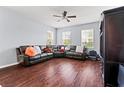 Spacious living room featuring hardwood floors, a ceiling fan and large windows at 9033 Aspen Hollow Pl, Riverview, FL 33578