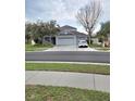 Charming home with a three car garage, lush landscaping, and a welcoming front porch at 9729 Asbel Estates St, Land O Lakes, FL 34638