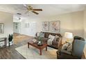 Inviting living room with wood floors, a ceiling fan, comfortable seating, and bright natural light at 9737 36Th N Way, Pinellas Park, FL 33782