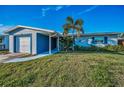 Charming one-story home featuring a well-manicured lawn, a palm tree, and a driveway leading to the attached garage at 11077 87Th Ave, Seminole, FL 33772