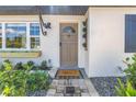 Inviting front entrance with decorative plants and a stylish 'Hello' doormat at 14066 Marguerite Dr, Madeira Beach, FL 33708