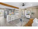 Open-concept living room boasts hardwood floors, modern decor and kitchen with stainless steel appliances at 14066 Marguerite Dr, Madeira Beach, FL 33708