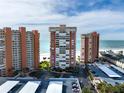 Aerial view of condo community by the beach with pools, well-manicured lawns, and parking at 17920 Gulf Blvd # 702, Redington Shores, FL 33708