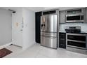 Kitchen with stainless steel appliances, sleek countertops, and direct access to hallway at 17920 Gulf Blvd # 702, Redington Shores, FL 33708