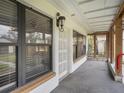 Covered porch with brick detail offers a view of the front door and large windows at 18108 Crooked Ln, Lutz, FL 33548
