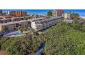 Aerial view of condo building, showcasing beach access, and nestled amid lush foliage at 19727 Gulf Blvd # 209, Indian Shores, FL 33785