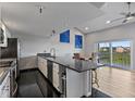 Open-concept kitchen with stainless steel appliances, granite countertops, and a seamless flow to the balcony at 19727 Gulf Blvd # 209, Indian Shores, FL 33785