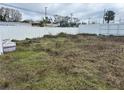 Image of a vacant lot with trash on it, enclosed with a white fence at 4104 W Osborne Ave, Tampa, FL 33614