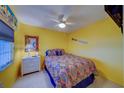 Cozy bedroom with bright yellow walls, ceiling fan, and complementary decor at 6033 113Th St # 213, Seminole, FL 33772