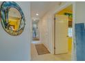 Bright hallway with neutral tones, decorative mirror, and access to various rooms at 6033 113Th St # 213, Seminole, FL 33772