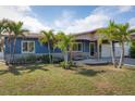 Charming single-story home with mature palms, covered carport, a welcoming porch swing, and manicured lawn at 10754 111Th N Pl, Largo, FL 33778