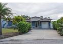Blue single-story home boasts a covered carport with a driveway, offering ample parking and protection from the elements at 10754 111Th N Pl, Largo, FL 33778