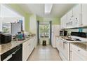 Functional kitchen with white cabinets, granite counters, and essential appliances at 10814 Brickside Ct, Riverview, FL 33579