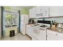 Bright kitchen featuring white cabinets, granite countertops, and modern appliances at 10814 Brickside Ct, Riverview, FL 33579