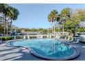 A beautifully maintained community pool surrounded by palm trees and plenty of lounge chairs at 1321 N Mcmullen Booth Rd # 1321, Clearwater, FL 33759