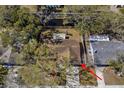 Home aerial view showing the property lines and surrounding neighborhood with mature trees at 1582 Sandalwood Dr, Dunedin, FL 34698