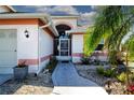 Front entrance with a secure screen door, and a charming walkway adorned with plants at 1601 E Del Webb Blvd, Sun City Center, FL 33573